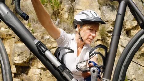 Senior-cyclist-checking-bicycle-at-countryside-4k