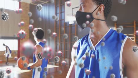 Animation-of-covid-19-cells-over-basketball-player-wearing-face-mask