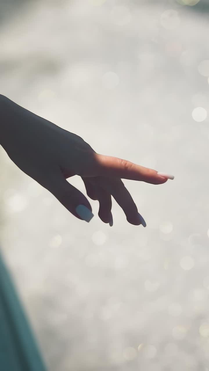 여자가 보트 창문 밖으로 손을 고 크루즈 클로즈업에서 물을 는 것을 즐기고 있습니다. 여자는 여름 휴가에 바다를 항해하는 물방울과 바람을 잡습니다.