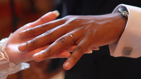 bride placing the wedding ring on her groom during their wedding ceremony