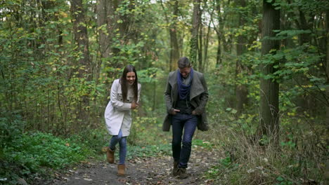 couple walking and laughing in the forest