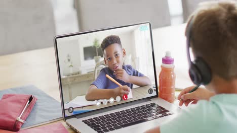 Kaukasischer-Junge-Nutzt-Laptop-Für-Videoanruf-Mit-Afroamerikanischem-Schulfreund-Auf-Dem-Bildschirm