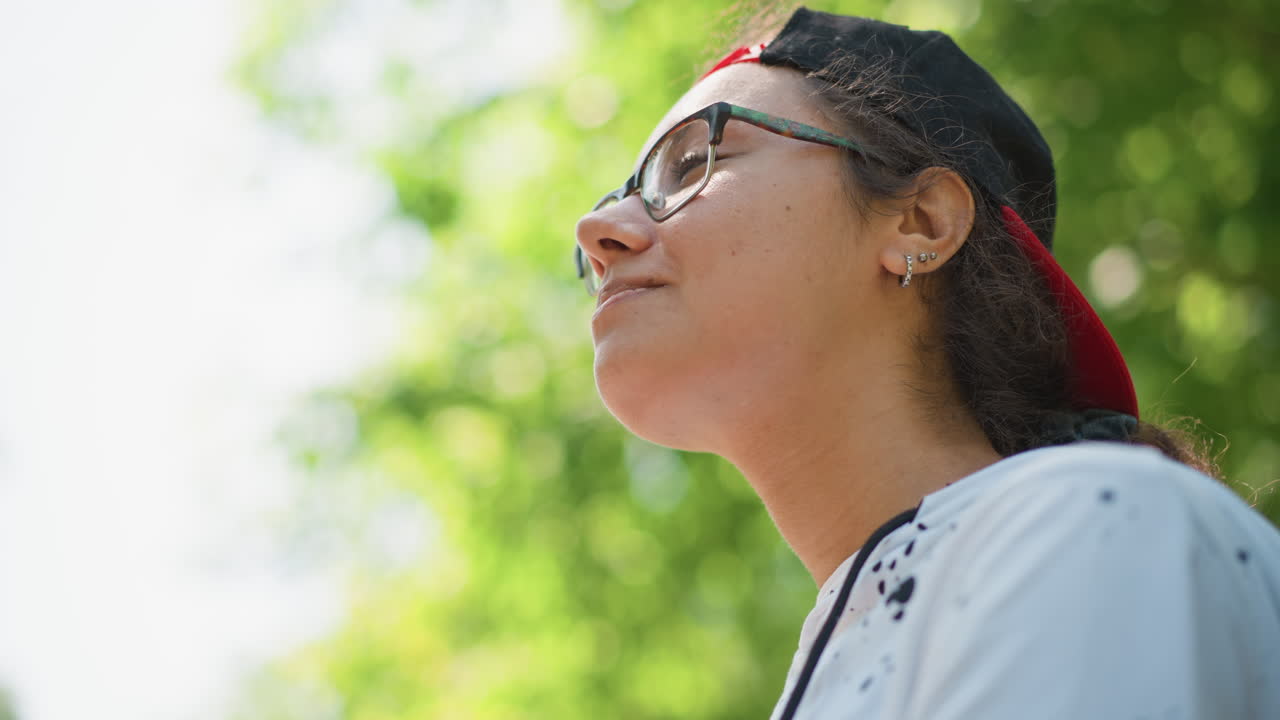 Adolescent relaxing on bench with tasty snack, Youthful individual savoring treat amidst lush green surroundings, Teenager relaxing and enjoying delicious snack in serene park environment