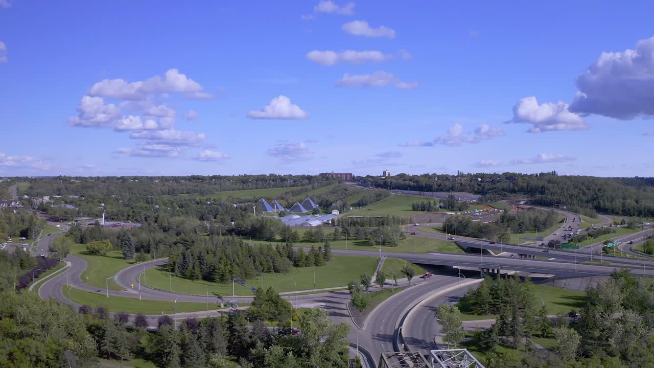Panaramic aerial 180 degrees over road headed downtown South East past the North Saskatchewan River flyover the historic steam paddle party dinner cruise boat by the lush green sunny public park