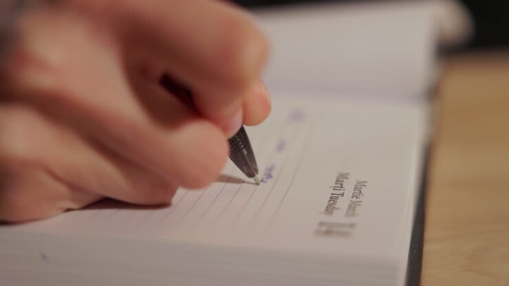 The Hand of a Woman Engaged in Writing - Close Up