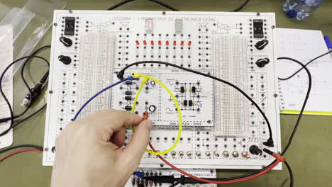 engineer hand experimenting with electronic components on breadboard