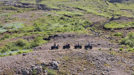 Tourist-on-quadbikes-standing-on-mountain-slope-in-Iceland,-aerial