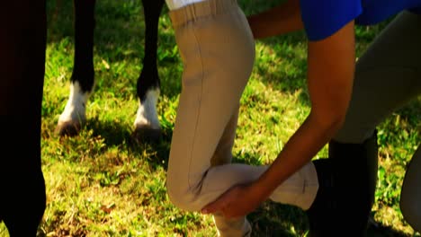 Mother-assisting-daughter-during-horse-riding-4k