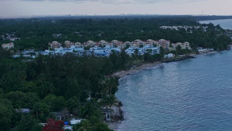 crane up drone shot of loiza cityscape with sand beach, atlantic ocean at sunset in puerto rico, usa