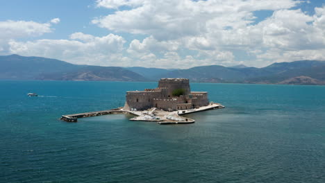 aerial view of bourtzi castle in middle of calm blue sea near nafplio in peloponnese, greece