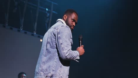 man performing on stage with microphone