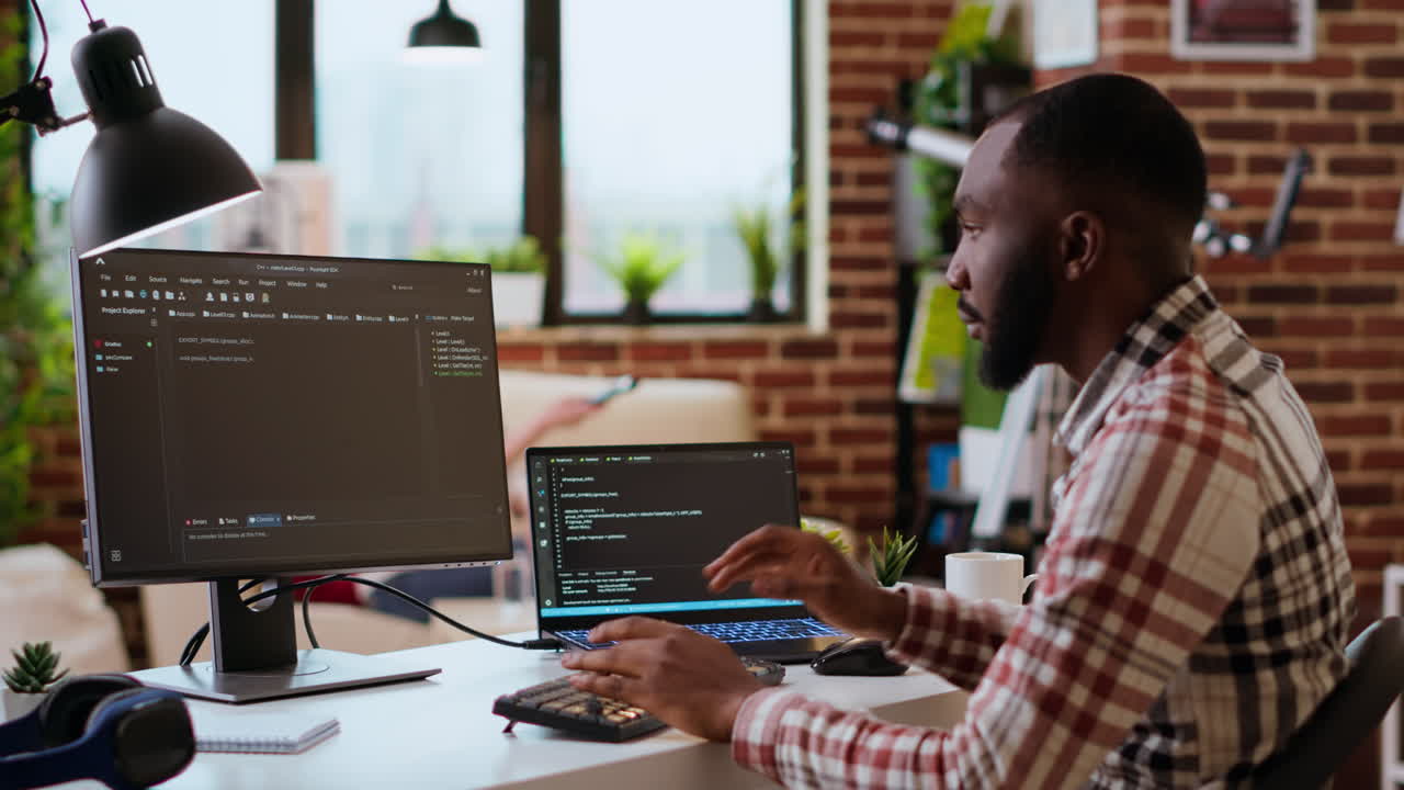 Young man seen programming software code on his laptop in a sleek home office