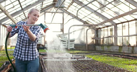 agricultora regando plantas en agricultura de invernadero 6