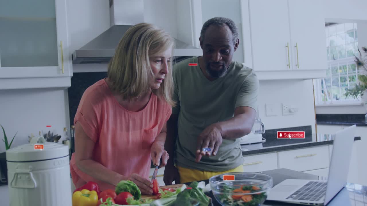 Play prompt initiating veggie dicing by woman and man scrolling laptop recipe for cooking tutorial