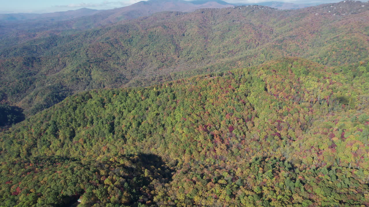 toma cinematográfica de drones de los colores del otoño en las montañas blue ridge en carolina del norte, con la montaña del abuelo en la distancia