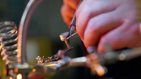 close-up of the hands of a caucasian man using a soldering tin iron while soldering some electrical contacts