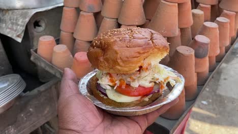 local burger with tomato and cucumber with kulhad or bhand in the background in gaya, bihar