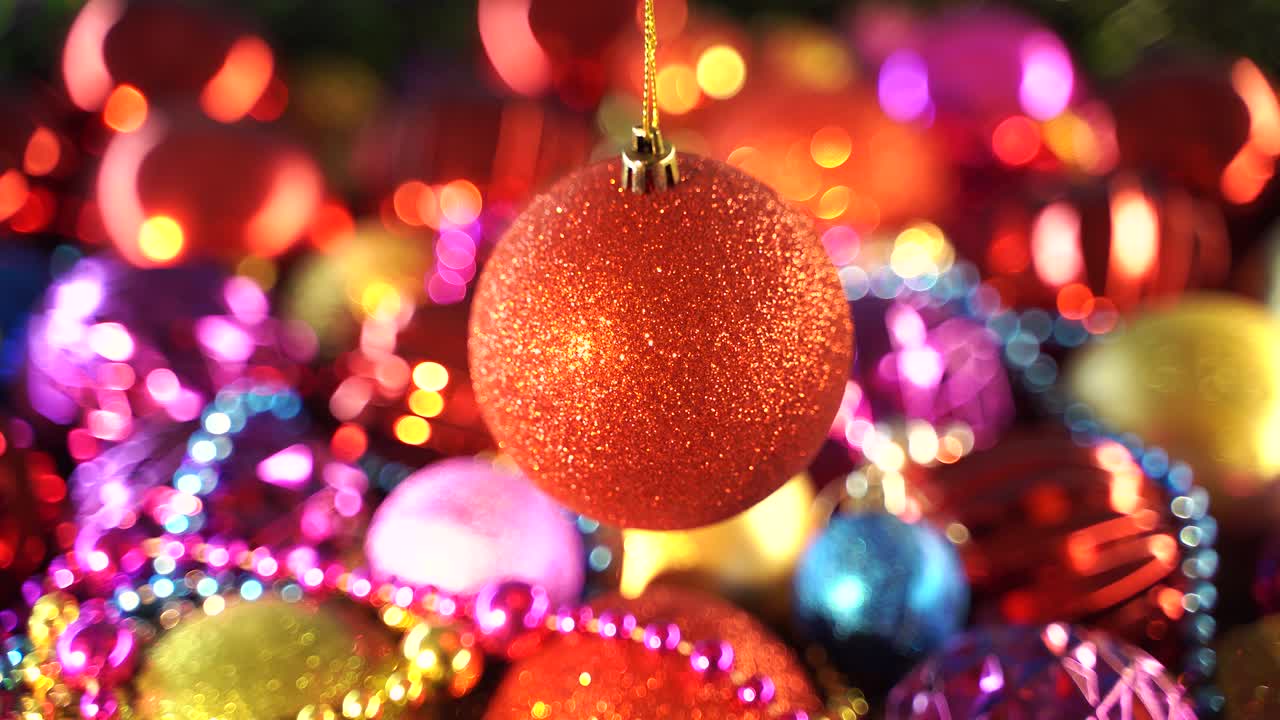 juguete de pelota roja brillando y iluminando la luz. decoración de navidad y año nuevo en fondo colorido. primer plano de un pelo rojo brillante