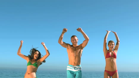 Attractive-friends-jumping-on-the-beach-at-the-same-time