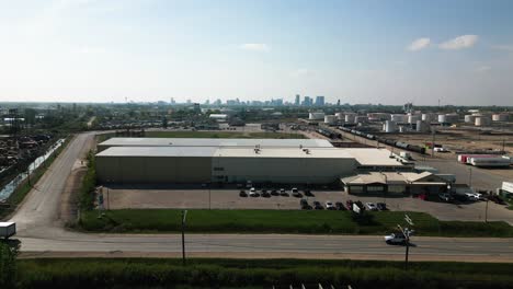 establishing 4k time-lapse drone out aerial shot of industrial factory semi zone manufacturing landscape distribution center district in downtown city winnipeg manitoba canada in distance