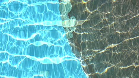 pure blue water in the swimming pool with light reflections in slow motion. aerial footage.