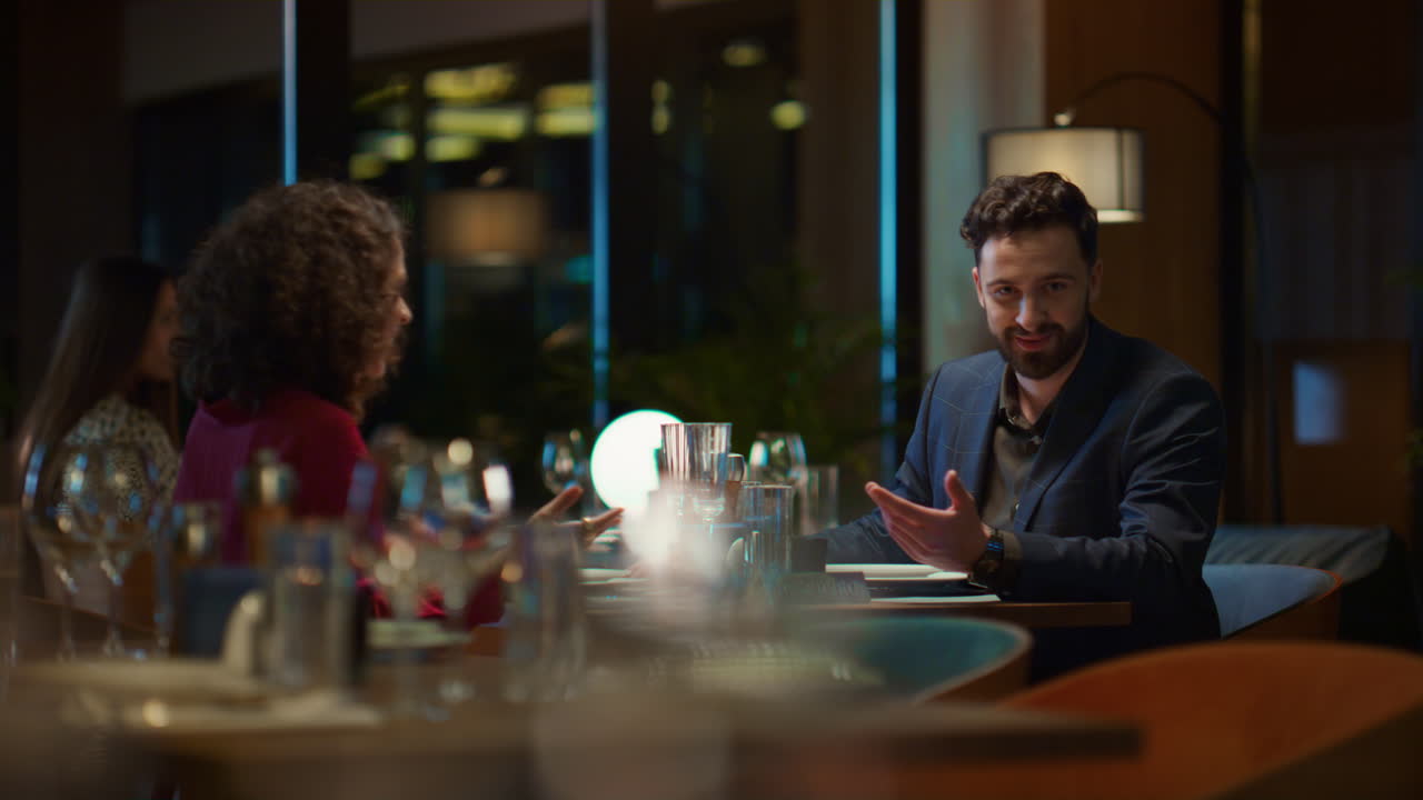 Fleretnisk par snakker sammen på aftenrestaurant. Par på middagsdate.
