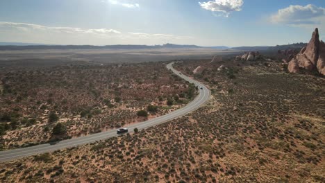 Drohnenvideo,-Das-Ein-Auto-Zeigt,-Das-Durch-Das-Malerische-Gelände-Des-Arches-Nationalparks-Fährt