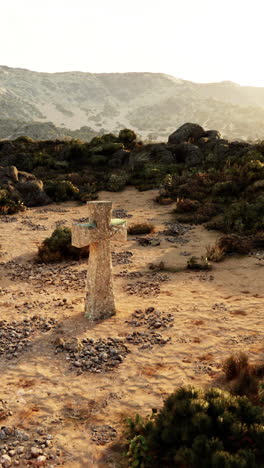 a stone cross in a desert landscape