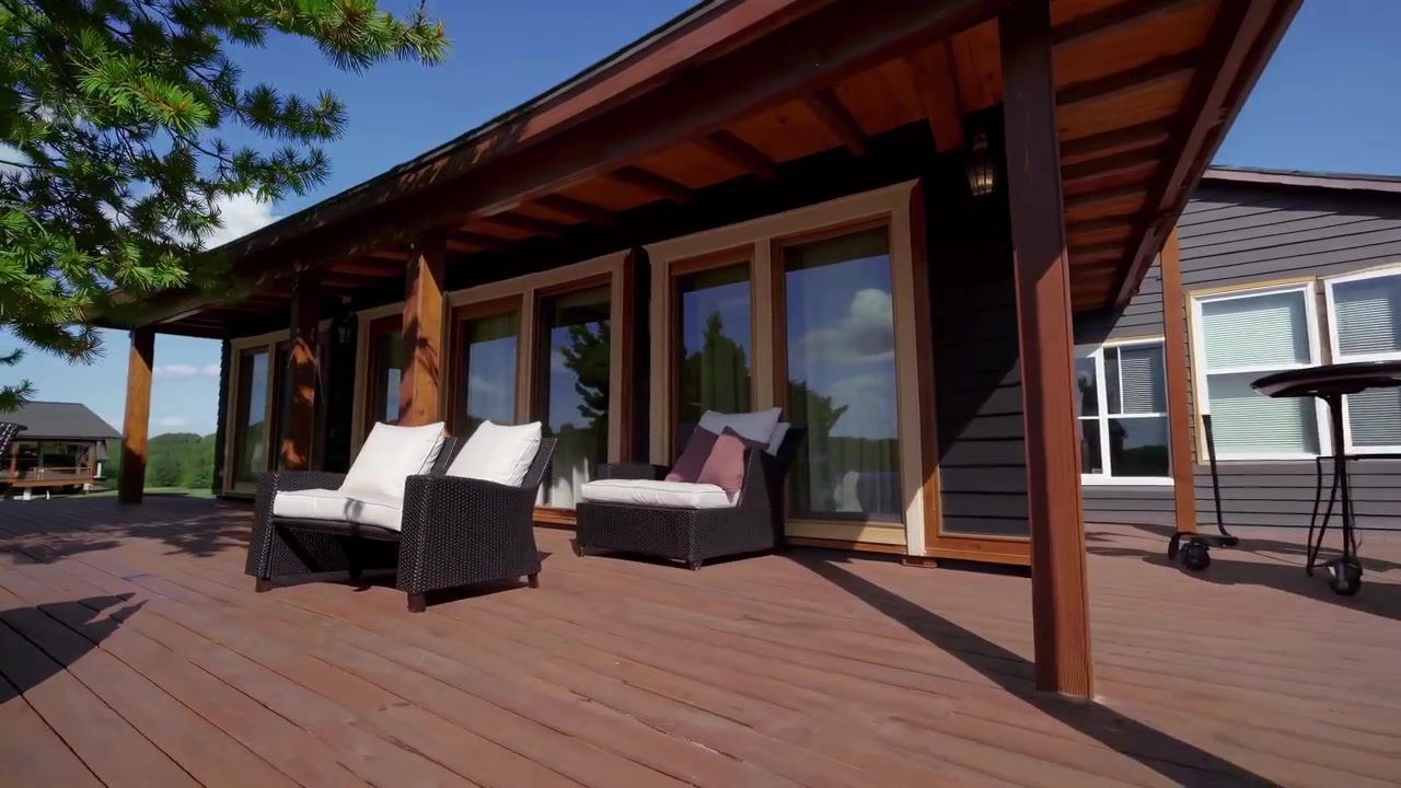 Vista aérea de una cabaña junto al lago con una terraza de madera
