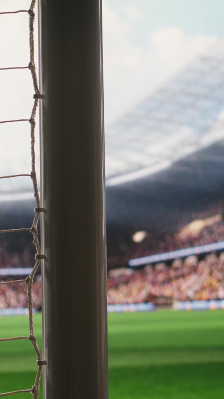 Vertical Video Angled soccer goal net and side post framing empty pitch with blurred stands