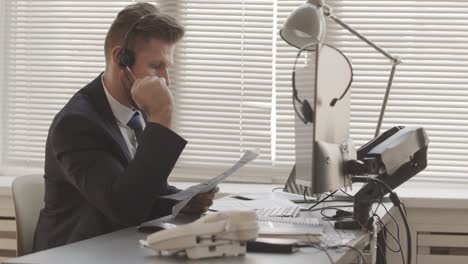 stock broker in headset talking to client in office