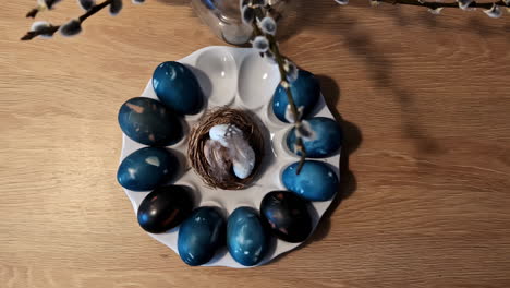 huevos de pascua azules adornados con marcas intrincadas, anidados en una canasta de mimbre contra un telón de fondo blanco prístino