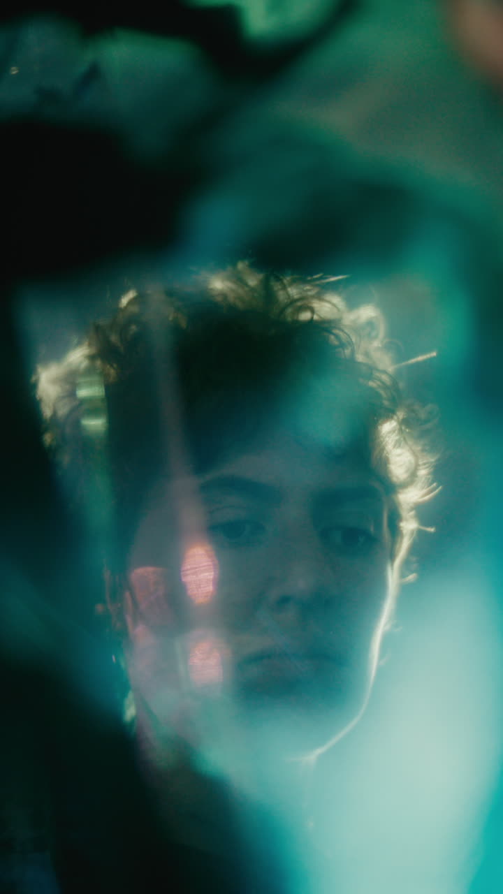 Young Woman Looking Up Surrounded by Abstract Glowing Light