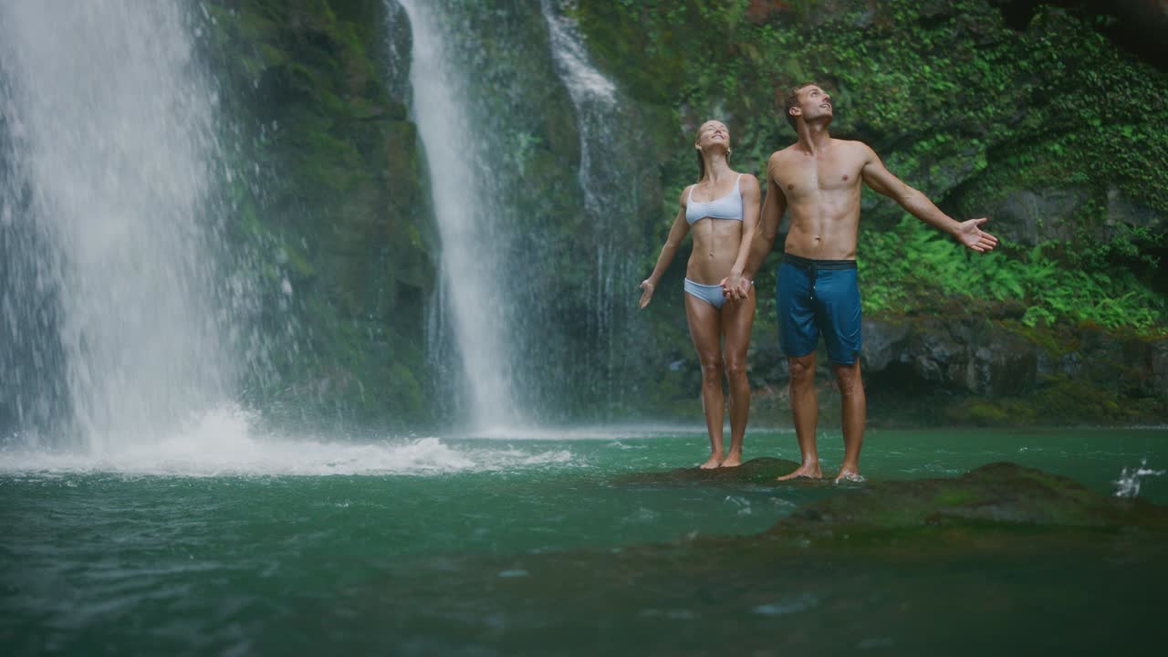 폭포 를 탐험 하는 젊은 부부