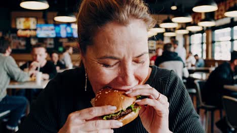 woman eating a burger in a restaurant