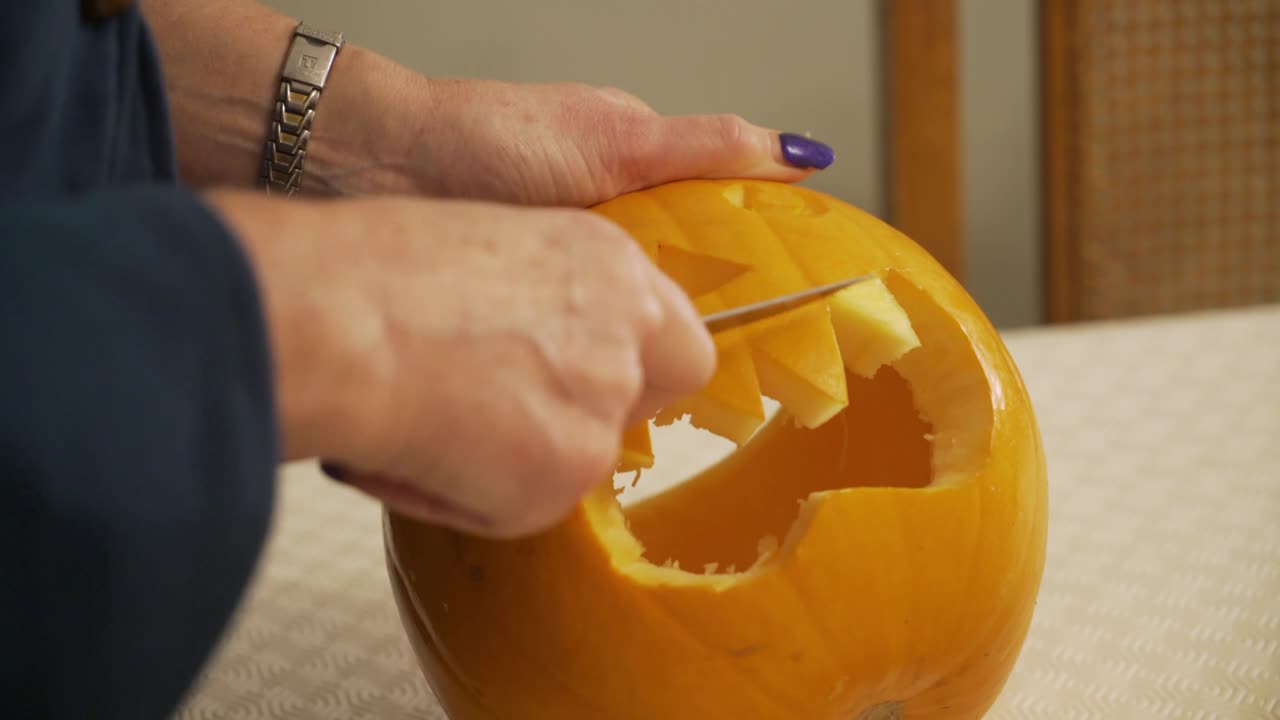 Close up carving a scary pumpkin. Halloween decorations and preparation