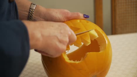 close up carving a scary pumpkin. halloween decorations and preparation