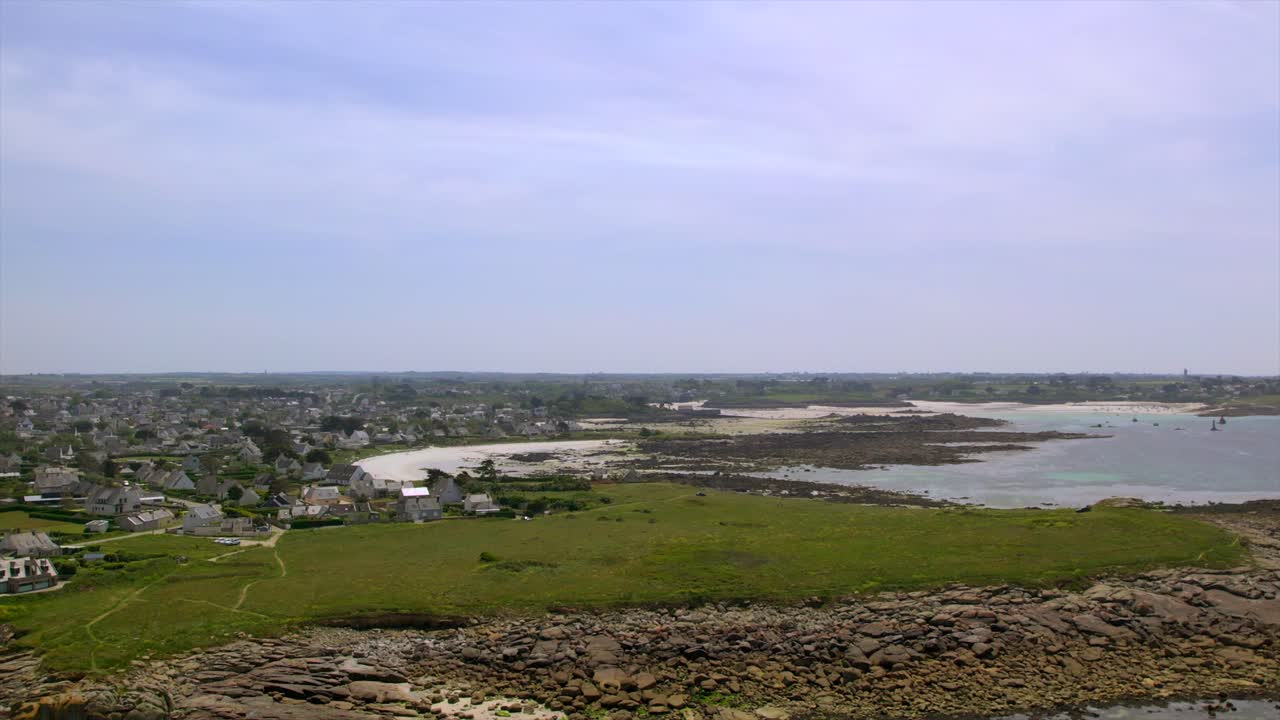 Coastal village near Brest, Brittany, with rocky shores, green grasslands, and tidal areas. This scenic seascape captures the charm of France’s Brittany region and its unique coastline. Drone aerial.