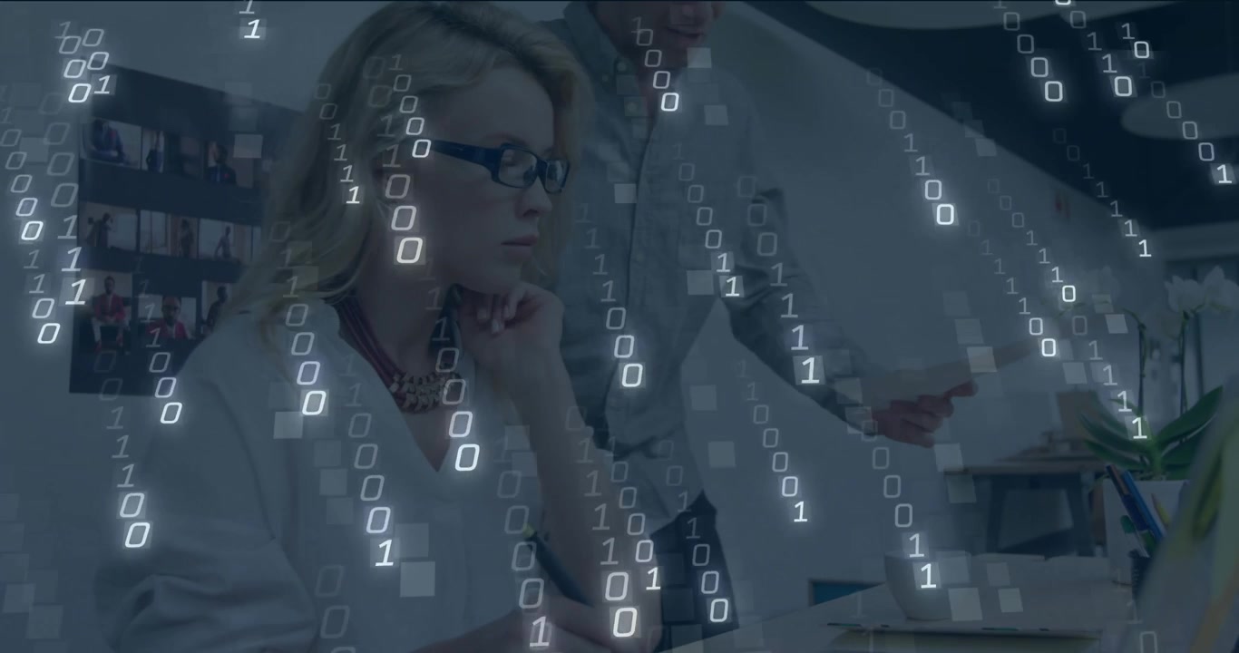 Two colleagues discussing technology data in office, with binary digits flowing across view