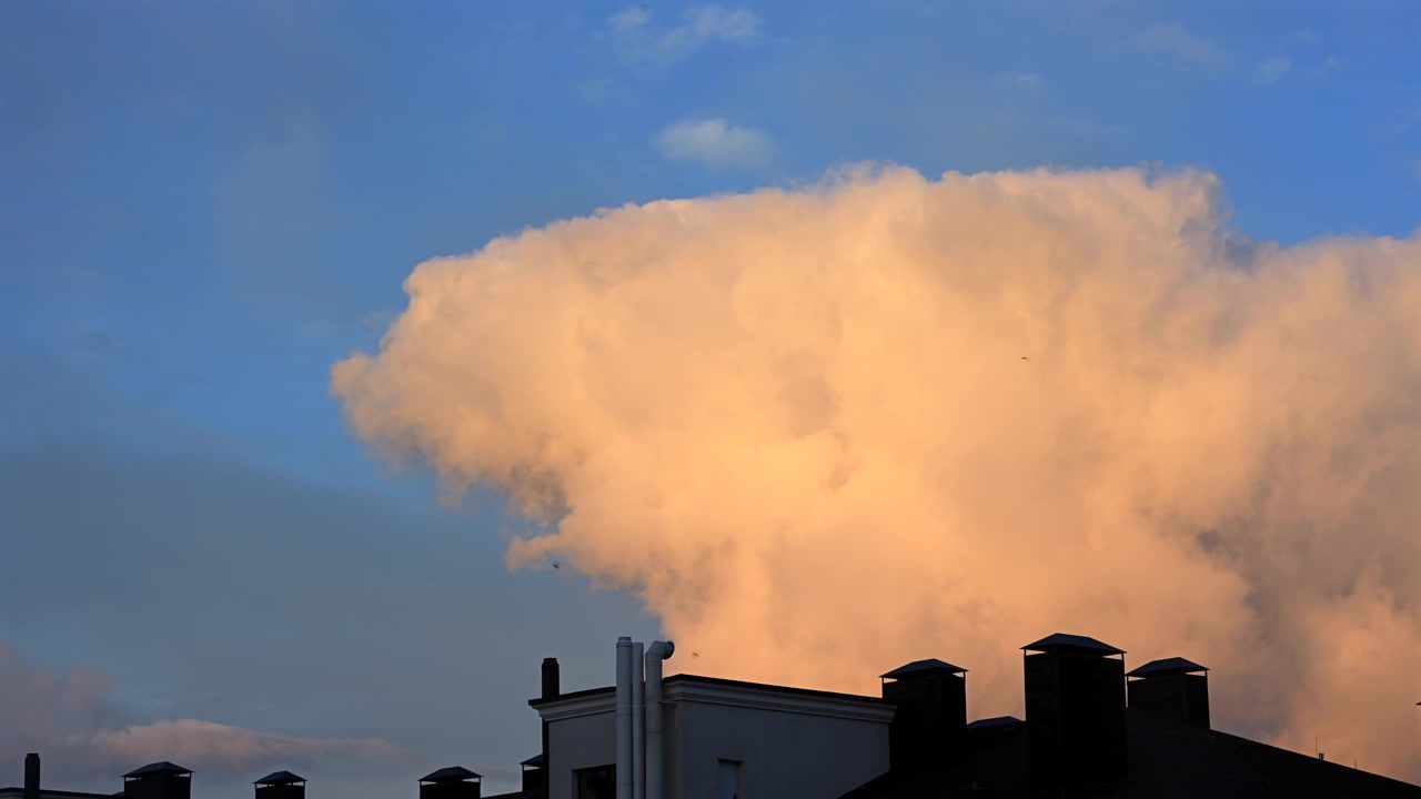 ゴールデンアワーに澄み切った青空へ劇的に立ち上る巨大な白い積乱雲。