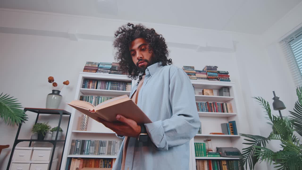 Young arabian man student reads book preparing for exam at university