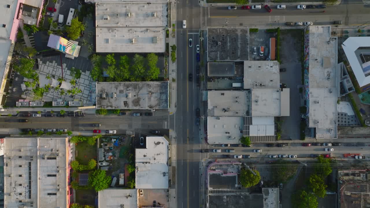 Vista aérea panorâmica de edifícios e ruas em um bairro urbano. Veículos circulando nas ruas e passando por cruzamentos. Miami, EUA.