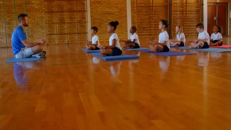 yoga instructor teaching yoga to school kids in school 4k