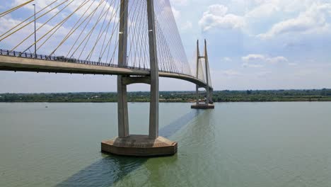 Aufsteigende-Drohnenaufnahme-Einer-Riesigen-Tsubasa-Brücke-Mit-Verkehr-über-Dem-Mekong-Fluss-In-Der-Nähe-Von-Phom-Penh