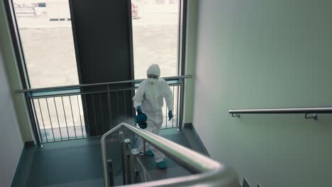 vista superior del trabajador de saneamiento desinfectando la escalera