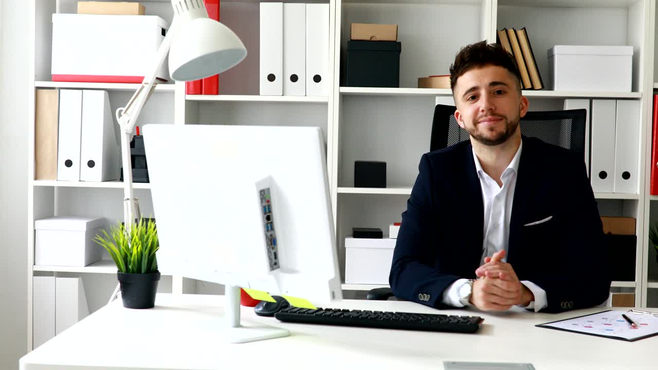 giovane uomo d'affari che fa un gesto e guarda la telecamera
