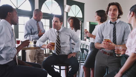 business colleagues meeting for after works drinks in bar making a toast