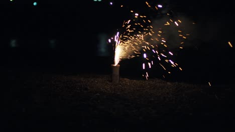 un pequeño fuego artificial hanabi brillando y estallando en el suelo en kyoto, japón por la noche - cerrar