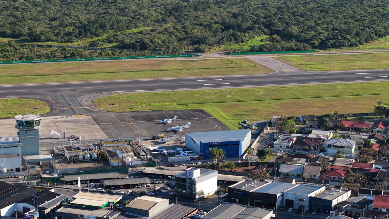 Perspective drone view of Navegantes International Airport terminal and runway surrounded by residential district, Navegantes, Santa Catarina, Brazil