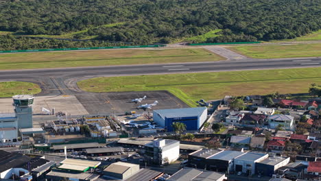 perspective drone view of navegantes international airport terminal and runway surrounded by residential district, navegantes, santa catarina, brazil